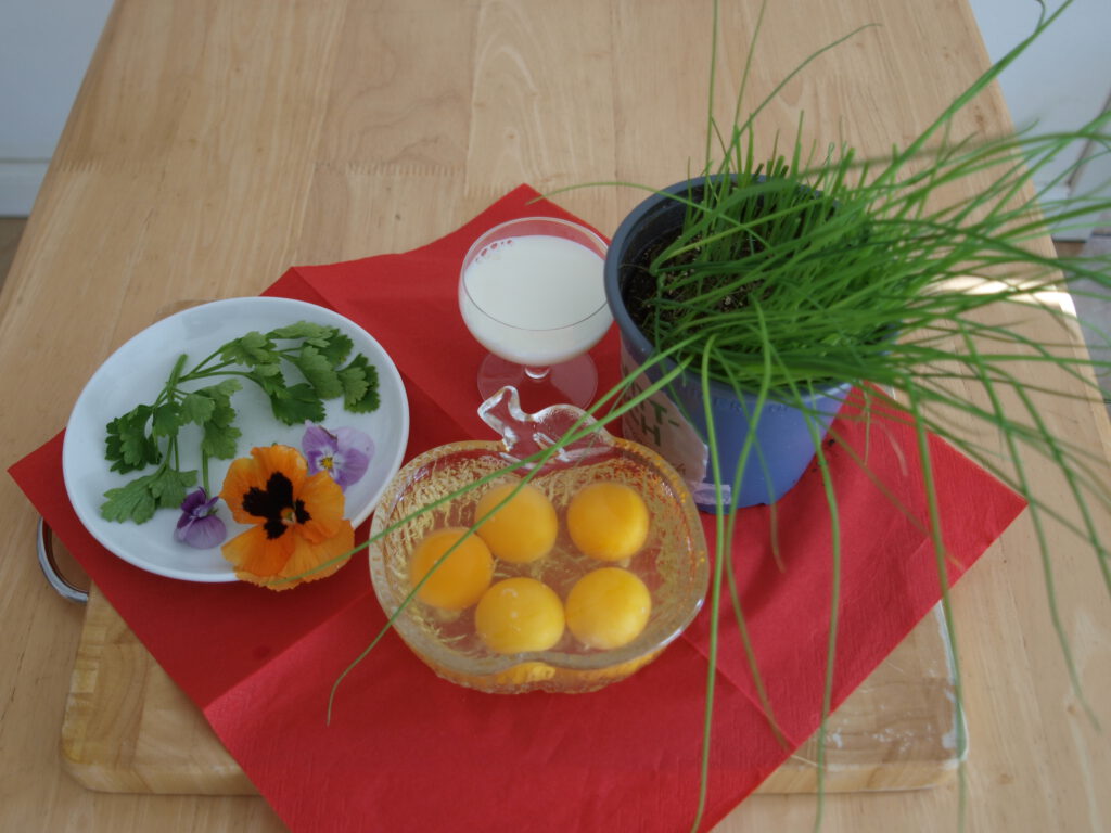 Zutaten für das Schnittlauch mit Rührei mit aufgeschlagenen Eier in Schale, Schnittlauch und Blumendeko