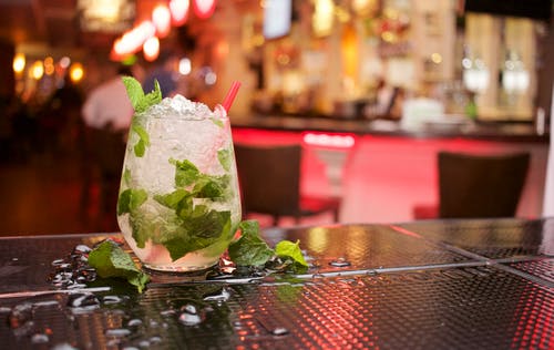 Glas Mojito an der Bar im Hintergrund ein Restaurant